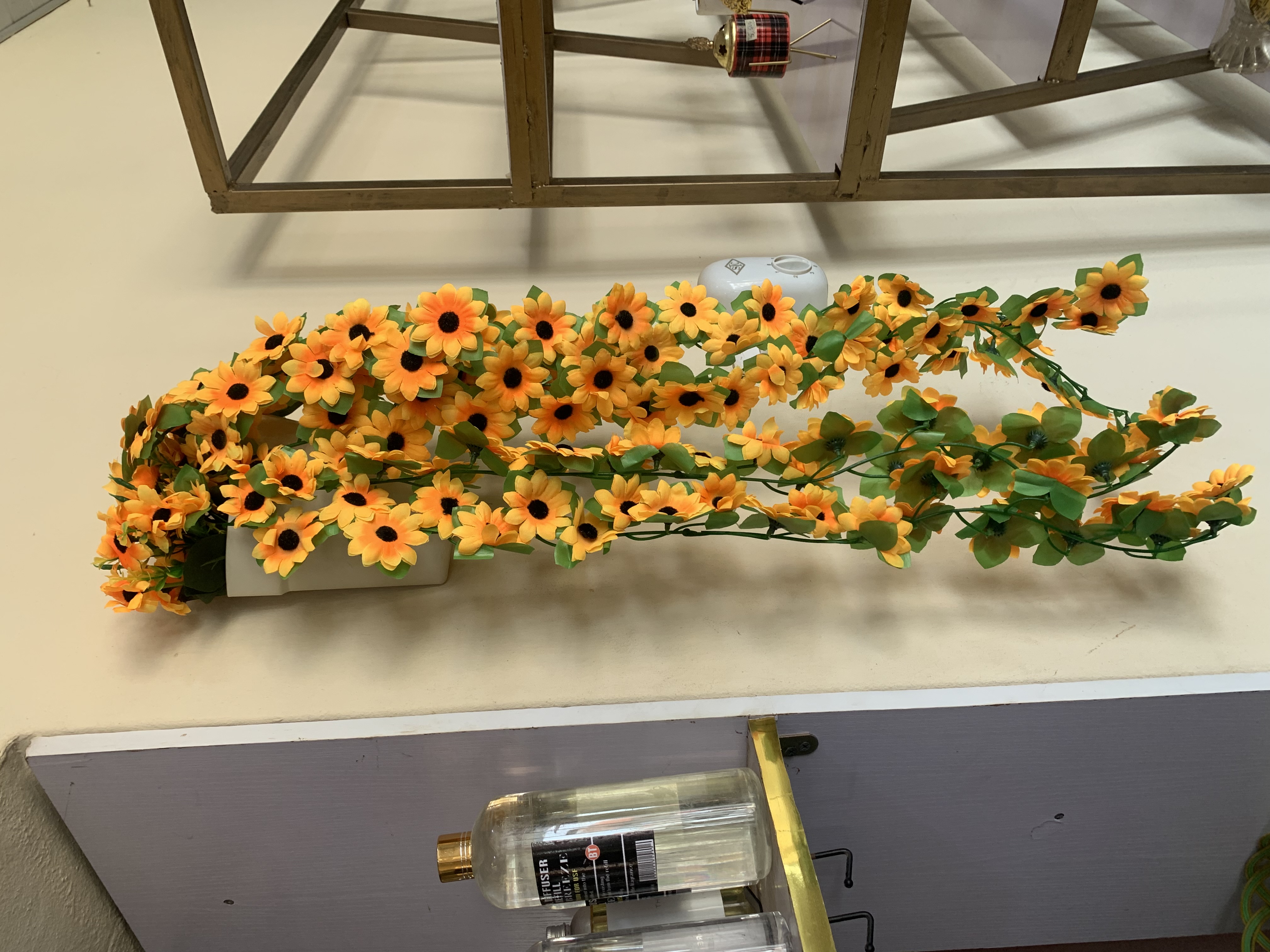 Dropping sunflowers in plastic wall vase Image